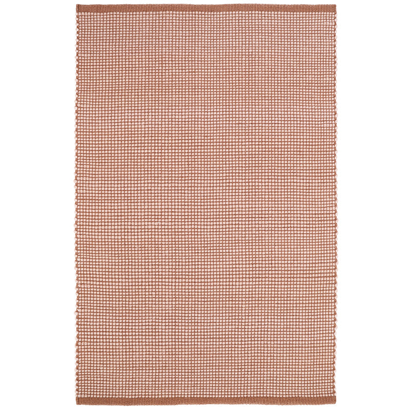 The pattern of this rug is a hand-woven base in a pink nude color revealing a thick yarn in pure felted wool.
