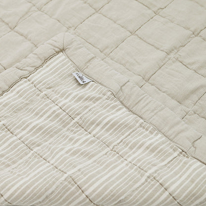 Anna is reversible: one side is plain and the other is striped, both with a quilted effect. Its subtle color, a sand complexion patinated by a stone wash which makes the cotton even softer.