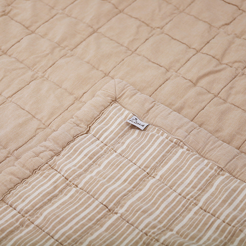 Anna is reversible: one side is plain and the other is striped, both with a quilted effect. Its subtle color, a terracotta complexion patinated by a stone wash which makes the cotton even softer.