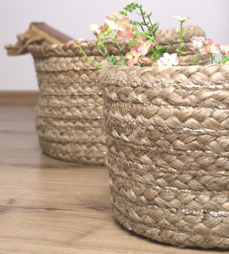 These baskets in jute and polyester are light beige, natural jute color and decorated with a golden thread. Its pattern is braided and its material is easy to maintain: a dry cleaning is enough.